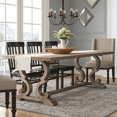 a dining room table with chairs and a bowl of flowers on top of the table