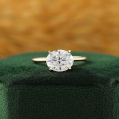 a diamond ring sitting on top of a green box