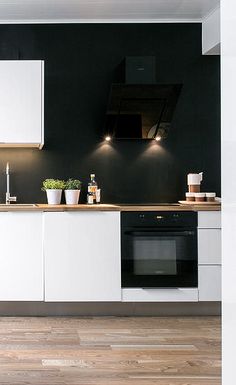 a kitchen with black walls and white cabinets