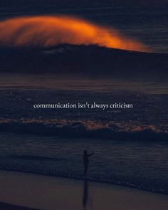 a person standing on top of a beach next to the ocean with an orange wave in the background