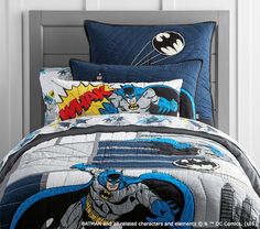 a bed with batman comforters and pillows on it