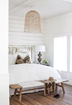 a bedroom with white walls and wood floors