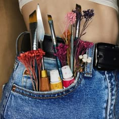 a woman's stomach with various makeup and beauty products in her jeans pocket,