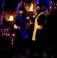 two men dressed in black and yellow standing next to each other with flames behind them