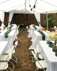 tables and chairs are set up under a white tent for an outdoor wedding or party