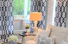 a living room with white furniture and blue curtains