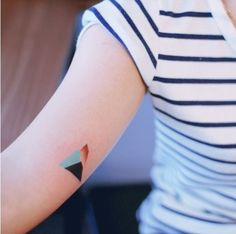 a woman with a small triangle tattoo on her arm