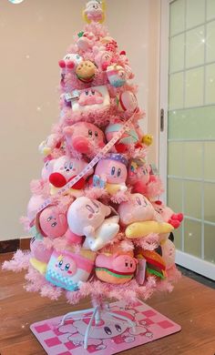 a pink christmas tree with lots of stuffed animals on it's top and bottom