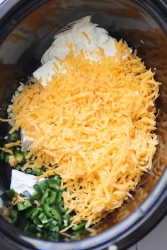 shredded cheese and other ingredients in the crock pot for slow cooker casserole