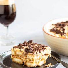 two pieces of dessert sitting on top of a plate next to a glass of wine