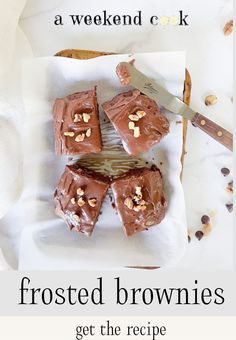 frosted brownies on a white plate with a knife and napkin next to it