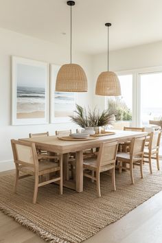 a dining room table and chairs in front of two large pictures on the wall above it