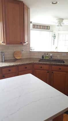 a kitchen with marble counter tops and wooden cabinets