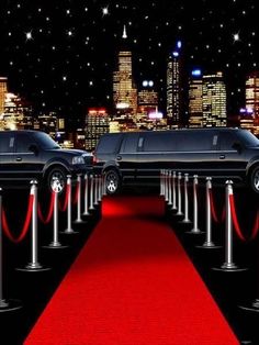 limousines lined up on a red carpet in front of a city skyline at night