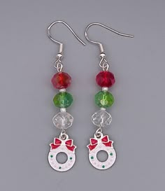 pair of earrings with red, green and white beads hanging from silver earwires