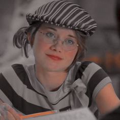 a woman wearing glasses and a striped hat