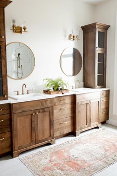 a bathroom with two sinks and wooden cabinets