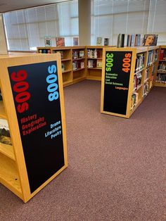 an empty library with bookshelves full of books and signs on the shelves for sale