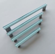 three metal handles on the back of a bench against a white background with no one in it