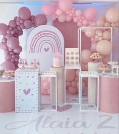 a pink and white birthday party with balloons, cake and desserts on the table