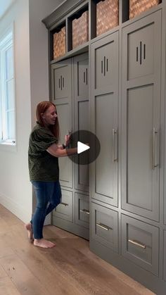 a woman standing in front of a large gray cabinet