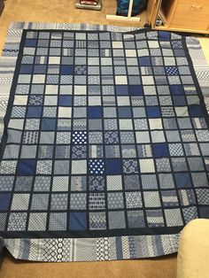 a blue and white quilt is laying on the floor