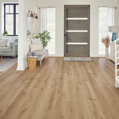 a living room filled with furniture and a wooden door in front of a white wall