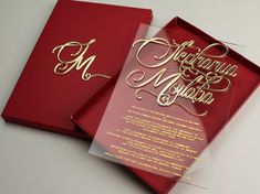 two red wedding cards with gold lettering on them