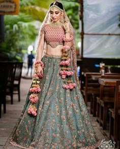 a woman in a green lehenga with pink flowers on the skirt and top