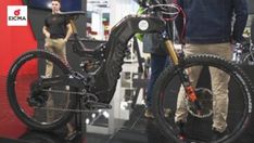 two men standing next to each other with bikes on display