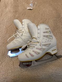 pair of white ice skates with lights on them sitting on top of a bed