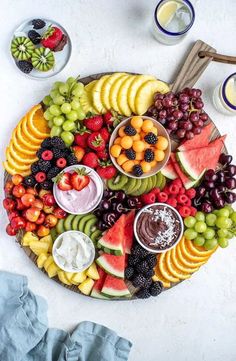 a platter filled with fruit and dips on top of a table