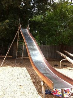 a wooden slide in the middle of a playground