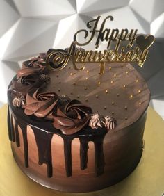 a birthday cake with chocolate frosting and gold decorations