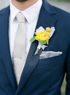 a man in a blue suit with yellow flowers on his lapel