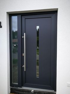 the front door is painted dark blue and has two sidelights on each side, along with a glass paneled entry door