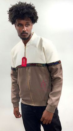 The Two-tone Jacket fused with Tilet embodies a harmonious blend of Ethiopian cultural heritage and contemporary fashion. Inspired by traditional Ethiopian craftsmanship, the jacket features a unique design that integrates two distinct tones, often contrasting colors like browns and white. This dual-tone effect adds visual interest. Ethiopian Clothing, Cultural Heritage, Contemporary Fashion, Ethiopia, Contrasting Colors, Two Tone, Unique Design, Gender Neutral, Art Collection