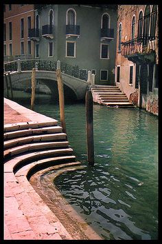 the water is green and there are many steps going up to it in the canal