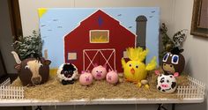 some farm animals are sitting in front of a red barn