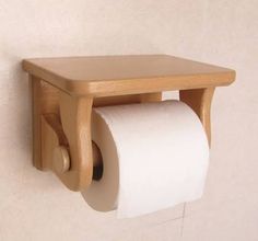 a wooden toilet paper holder on the wall