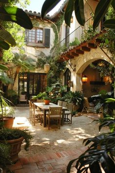 an outdoor dining area with potted plants and tables in the middle of the courtyard