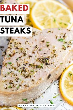 A close-up of a juicy baked tuna steak on a metal sheetpan with fresh sliced lemons and text overlayed.