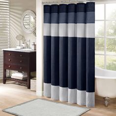 a bathroom with a bathtub, sink and shower curtain in blue and white colors