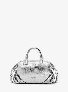 The epitome of downtown cool, our Darrington satchel is softly structured in metallic crushed leather with buckle-fastening details that will punctuate any look. Its fully-lined interior features a slip pocket to keep just the essentials neatly organized. Adjust the crossbody strap to your desired length. Leather Satchel Bag, Michael Kors Collection, Leather Shops, Leather Silver, Metallic Leather, Leather Satchel, Crossbody Strap, Satchel Bags, Satchel