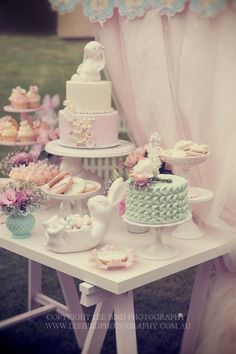 a table topped with lots of cakes and cupcakes on top of each other