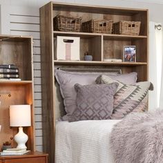 a bed room with a neatly made bed and some bookshelves on the wall