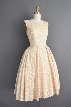 "Gorgeous vintage 1950s cocktail party dress in an outstanding Champagne gold threading throughout. This vintage dress features a very flattering fitted bodice with a shelf bust fit, defined nipped waist, and a heavy free full skirt. There is a back metal zipper for closure. ✂------ M E A S U R E M E N T S ------- Best Fit: XS Bust: 33\" Waist: 24\" Hips: open fit Shoulders: undefined Total Length: 42.5\" Material: lace Condition: Excellent vintage condition. Ready to wear. ☆ Layaway is availabl Vintage Fitted A-line Tea Length Dress, Vintage Full Skirt Wedding Dresses, Vintage Fashion Tea Length Dress With Fitted Bodice, Vintage Dresses With Pleated Bodice For Vintage Events, Tea Length Dress With Fitted Bodice For Vintage Fashion, Fitted Bodice Full Skirt Dress For Vintage Events, Retro Full Skirt Wedding Dress, Vintage Dresses With Pleated Bodice And Tea Length, Vintage Tea Length Dress With Pleated Bodice