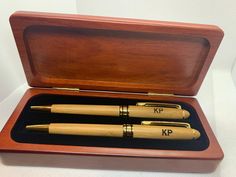 two wooden pen sets in a box on a table