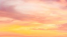 an airplane is flying in the sky at sunset or sunrise with pink and yellow clouds