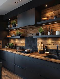 a kitchen with wooden walls and black cabinets, potted plants on the counter top